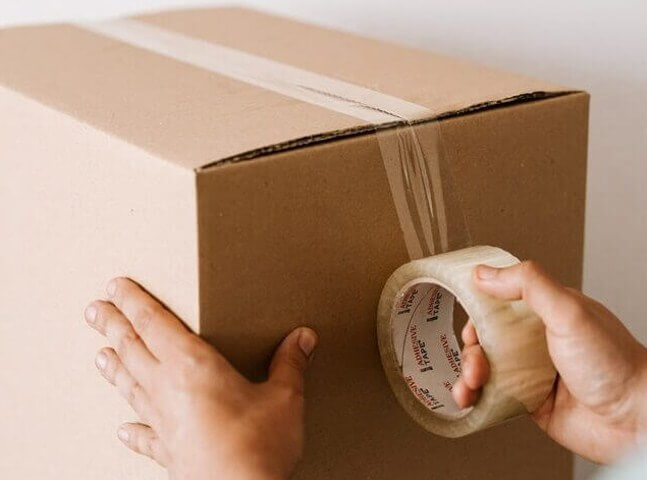 A Data Center Remote Hands Staff are packing a box for an RMA return